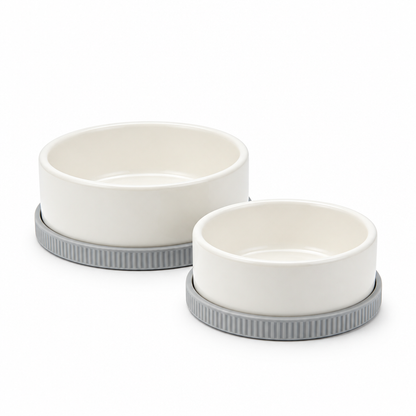 Two ivory pet bowls on gray ribbed bases against white